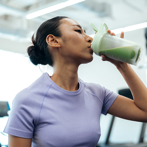 Junge Frau trinkt ihren Fitness Shake